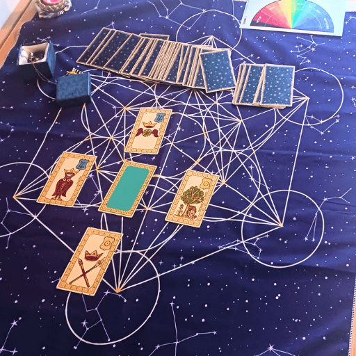 Tirage de tarot Doigt de Lumière sur tapis astrologique bleu avec cartes disposées en schéma géométrique