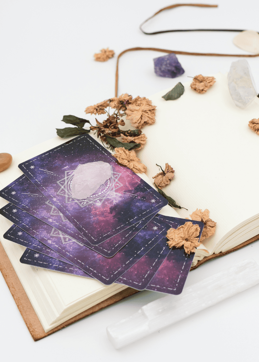 Cartes de guidance avec quartz rose et cristaux pour soins énergétiques sur livre ouvert